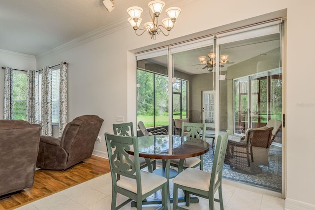 dining area featuring light hardwood / wood-style floors, a notable chandelier, ornamental molding, and plenty of natural light