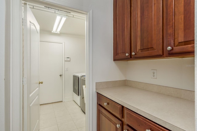 clothes washing area with washer and clothes dryer and light tile patterned floors