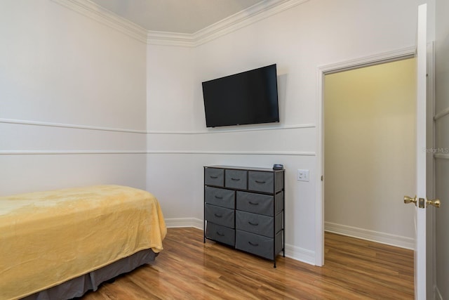 bedroom with ornamental molding and hardwood / wood-style flooring