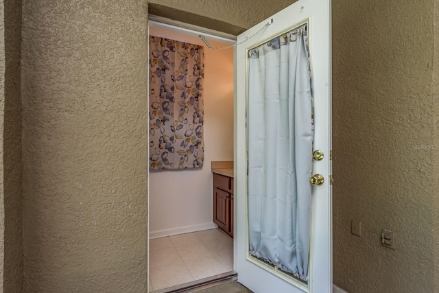 interior space featuring vanity, a textured ceiling, and tile patterned flooring