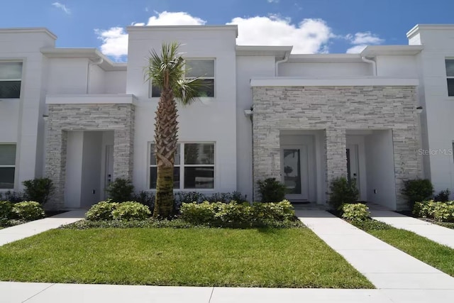 townhome / multi-family property featuring a front yard