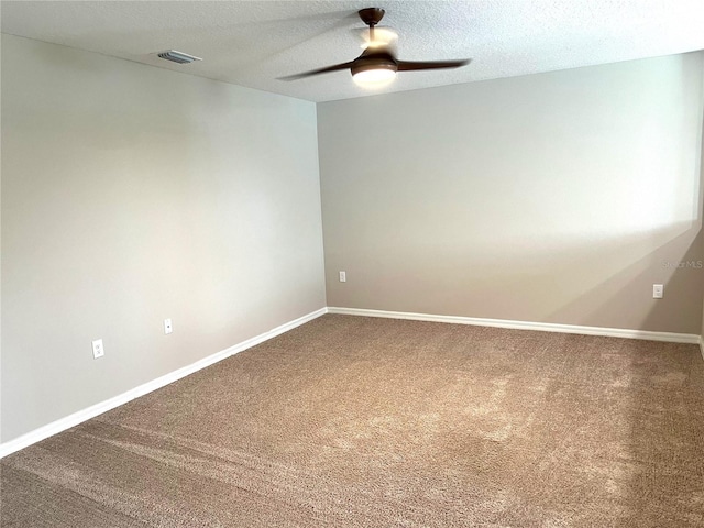 spare room with visible vents, ceiling fan, baseboards, and carpet