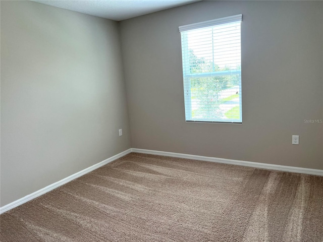 unfurnished room with baseboards and carpet floors