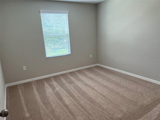 carpeted empty room with baseboards