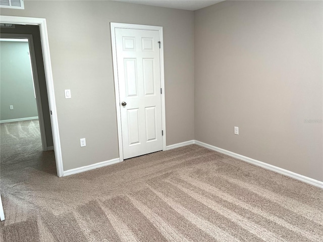 unfurnished bedroom with carpet flooring, visible vents, and baseboards