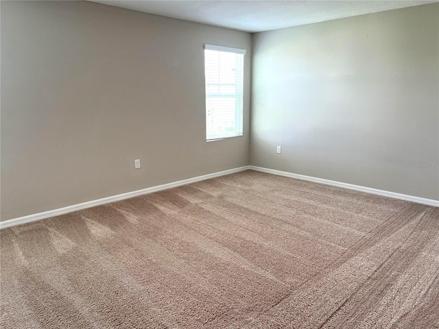 unfurnished room with carpet floors and baseboards