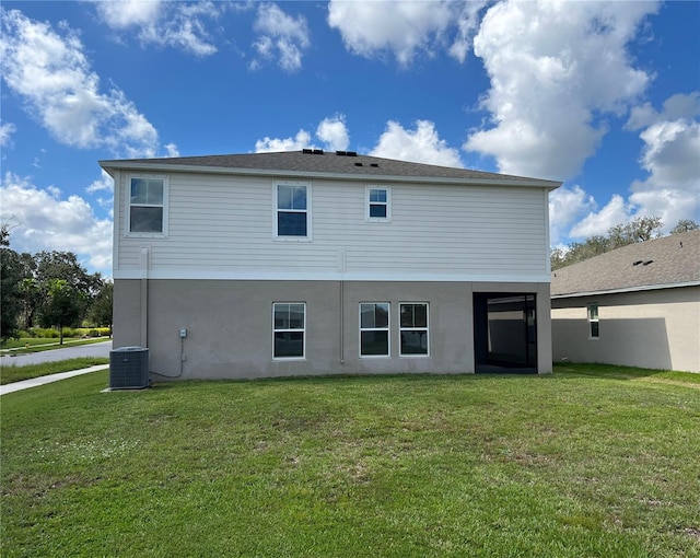 rear view of property with cooling unit, stucco siding, and a lawn