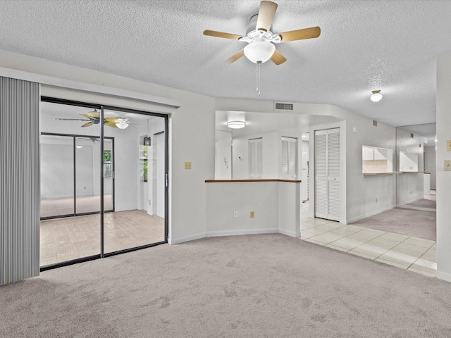 unfurnished living room with ceiling fan, light colored carpet, and a textured ceiling