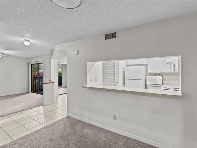 empty room with a textured ceiling and light tile patterned floors