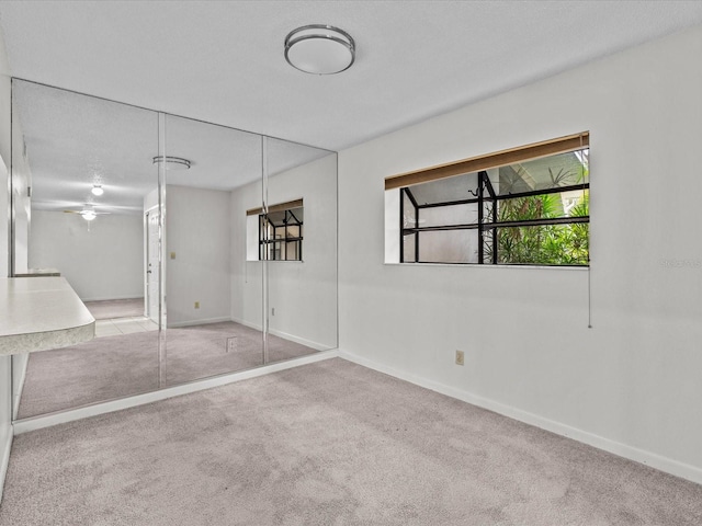 unfurnished bedroom featuring a closet and light colored carpet