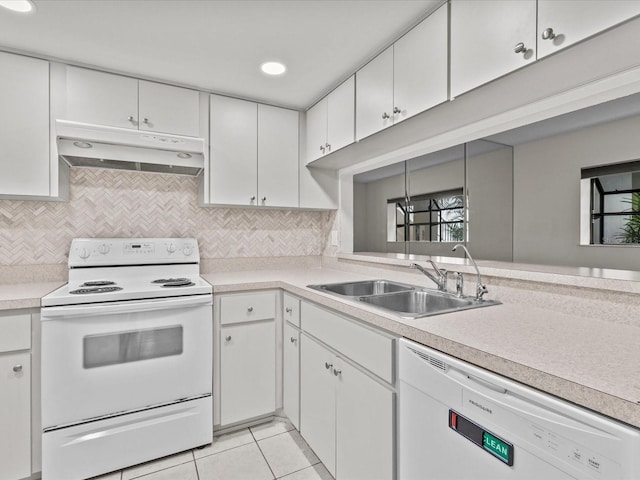 kitchen with light tile patterned floors, white cabinets, sink, and white appliances