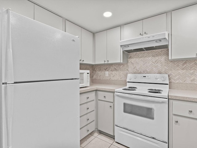 kitchen with white cabinets, white appliances, light tile patterned floors, and tasteful backsplash