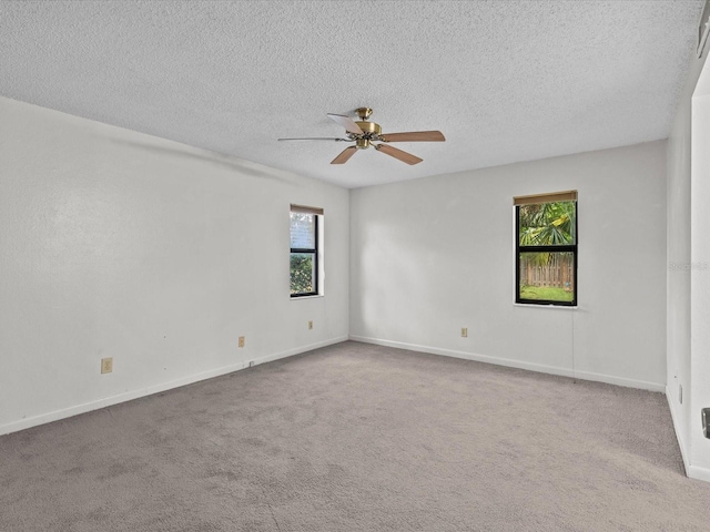 empty room featuring light carpet, ceiling fan, and a textured ceiling