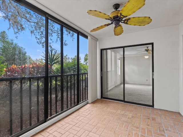 unfurnished sunroom featuring ceiling fan