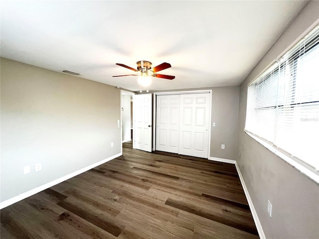 unfurnished bedroom featuring ceiling fan, a closet, and dark hardwood / wood-style floors