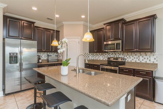 kitchen with appliances with stainless steel finishes, hanging light fixtures, light stone countertops, ornamental molding, and sink