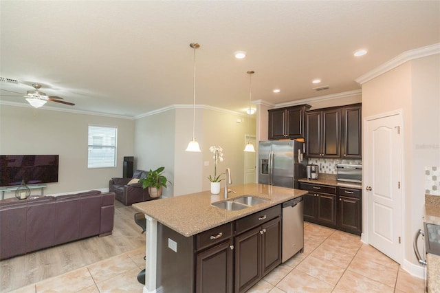 kitchen featuring dark brown cabinets, an island with sink, appliances with stainless steel finishes, and sink