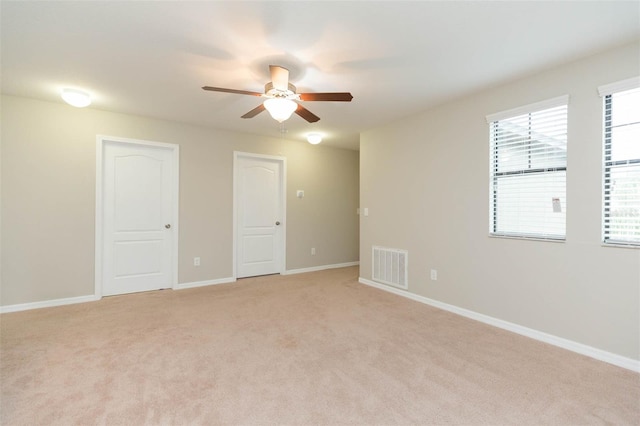 spare room with light carpet and ceiling fan