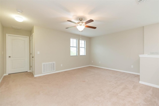 spare room featuring ceiling fan and light colored carpet