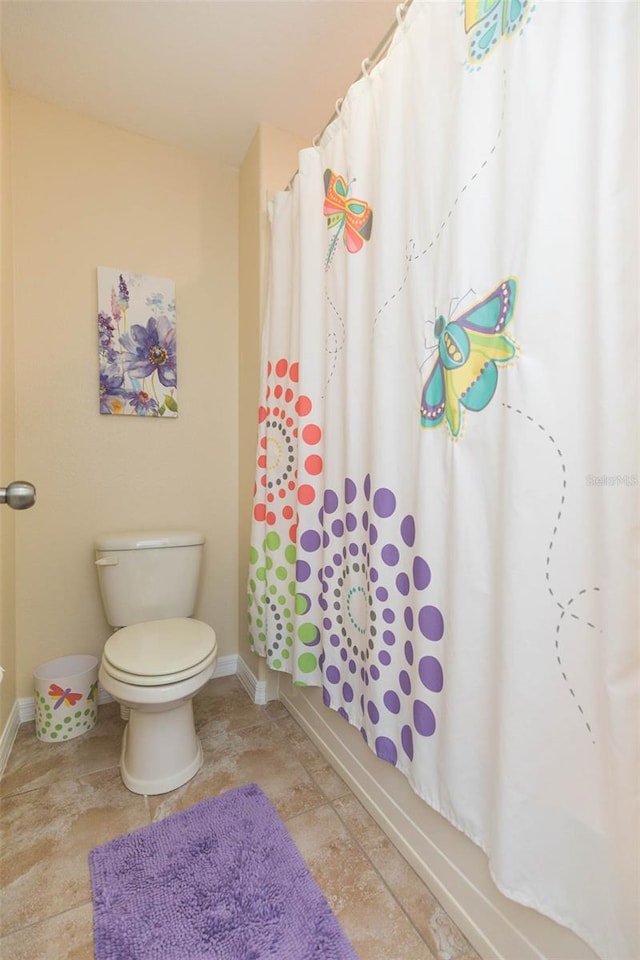 bathroom with shower / bathtub combination with curtain and toilet