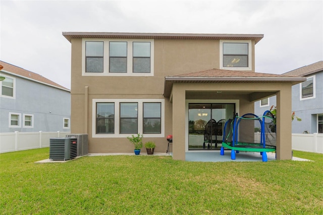 back of house featuring central AC and a yard