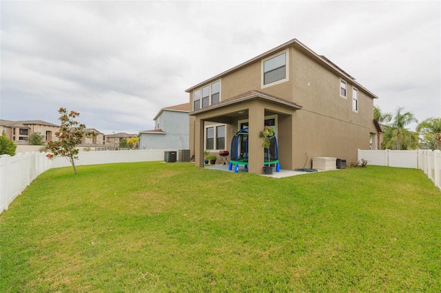 rear view of property featuring cooling unit and a yard