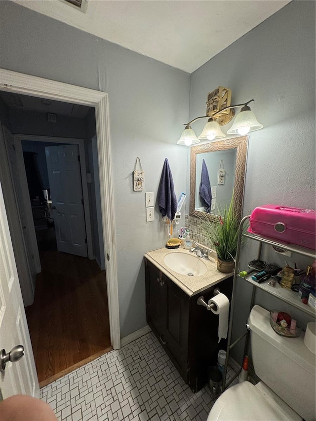 bathroom with hardwood / wood-style floors, vanity, and toilet