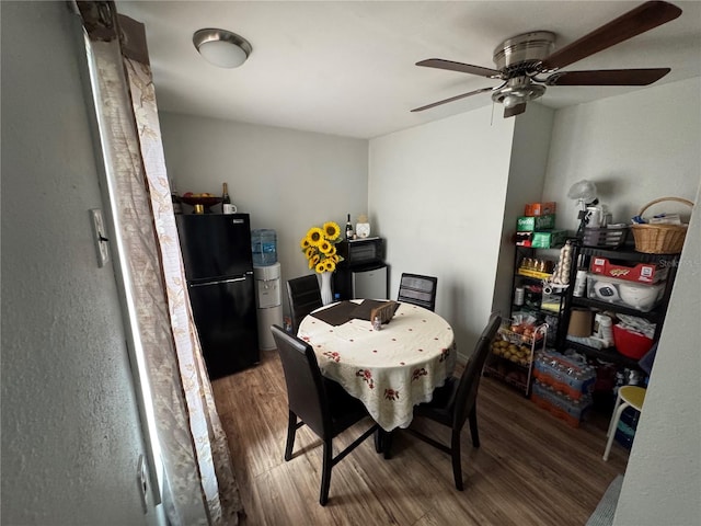 dining space with ceiling fan and hardwood / wood-style flooring