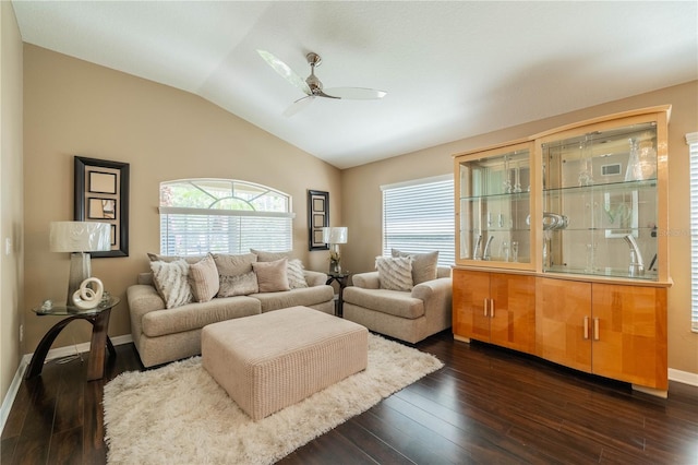 living room with ceiling fan, vaulted ceiling, and dark wood-type flooring