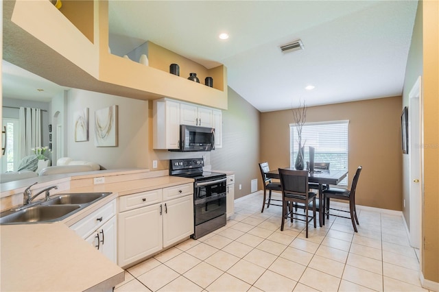 kitchen featuring black range with electric stovetop, sink, white cabinets, lofted ceiling, and light tile patterned floors