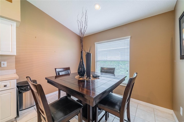 dining room featuring vaulted ceiling and light tile patterned floors