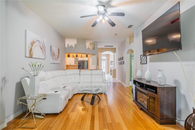 living room featuring light wood-type flooring and ceiling fan