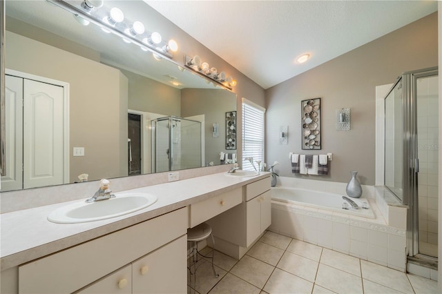 bathroom with independent shower and bath, lofted ceiling, vanity, and tile patterned floors