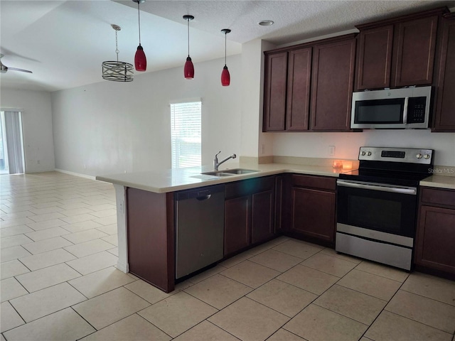 kitchen with kitchen peninsula, hanging light fixtures, light tile patterned floors, sink, and stainless steel appliances