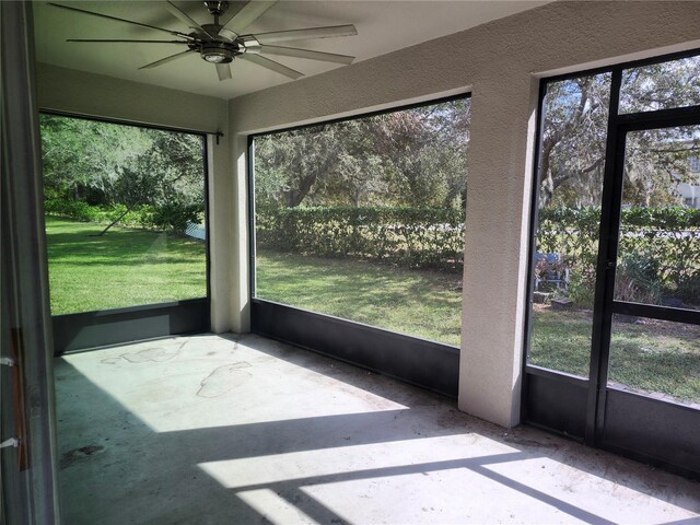 unfurnished sunroom featuring ceiling fan