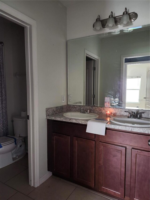 bathroom featuring vanity, toilet, and tile patterned flooring