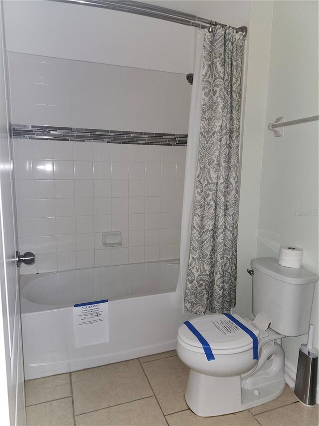 bathroom with toilet, shower / bathtub combination with curtain, and tile patterned flooring