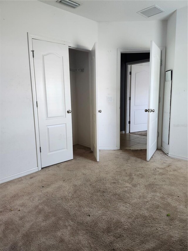 unfurnished bedroom featuring light carpet