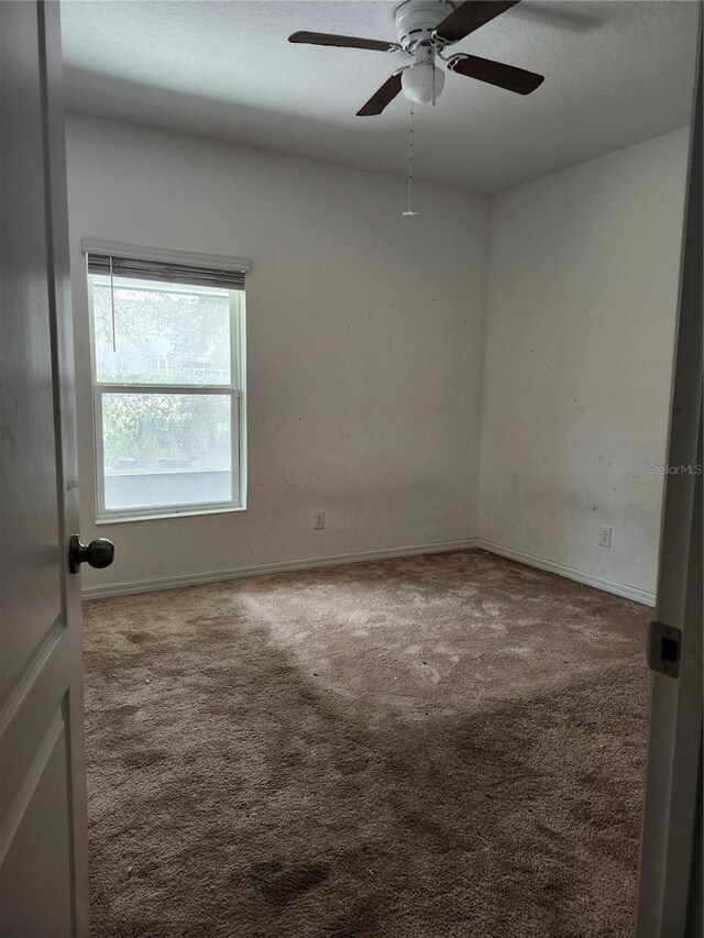 carpeted empty room featuring ceiling fan