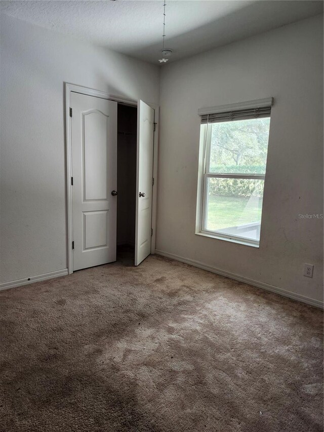 unfurnished bedroom featuring light carpet