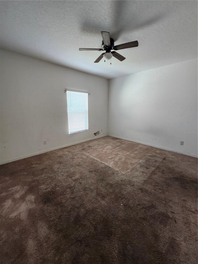 spare room with a textured ceiling, carpet floors, and ceiling fan