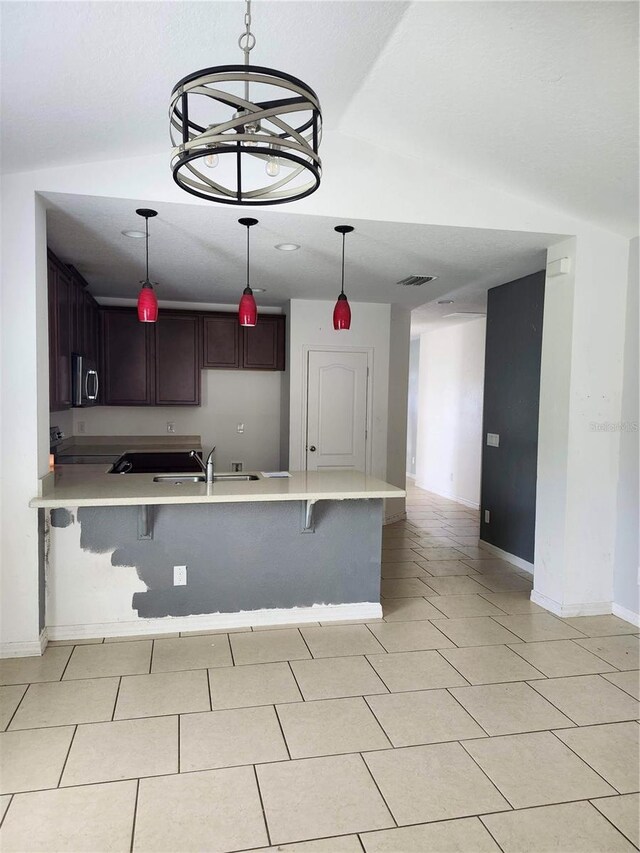 kitchen featuring sink, a chandelier, a breakfast bar, and kitchen peninsula