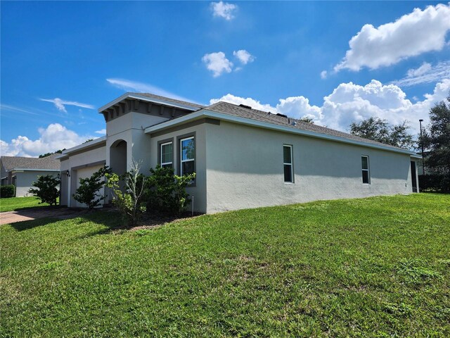 view of side of property featuring a lawn and a garage