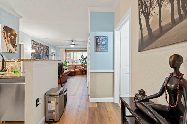 hall with light hardwood / wood-style floors and ornamental molding