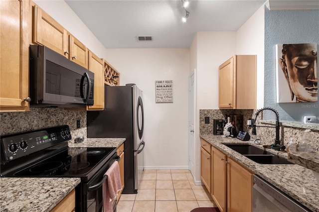 kitchen with light stone counters, light brown cabinetry, appliances with stainless steel finishes, and sink