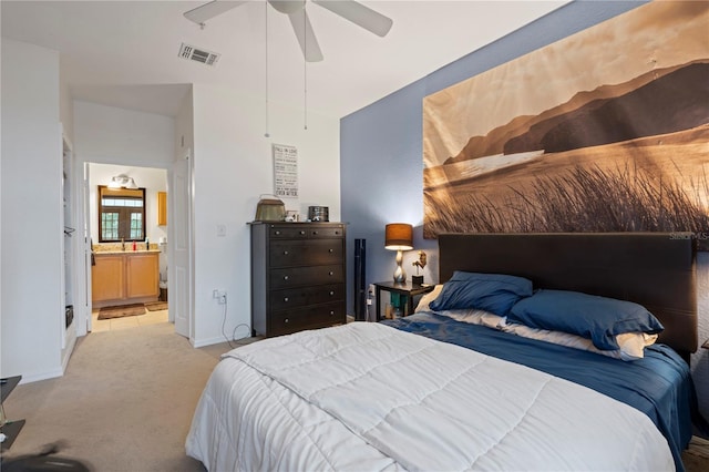 bedroom featuring ceiling fan, ensuite bath, and light carpet