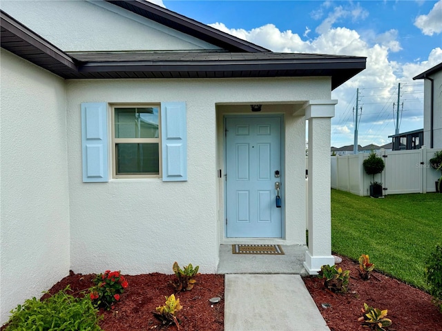 doorway to property featuring a lawn