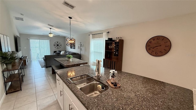 kitchen with white cabinets, hanging light fixtures, a healthy amount of sunlight, and sink