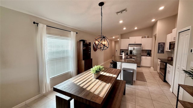 tiled dining space with a notable chandelier and lofted ceiling