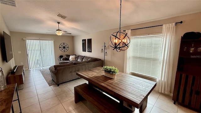 dining area with ceiling fan with notable chandelier and light tile patterned floors